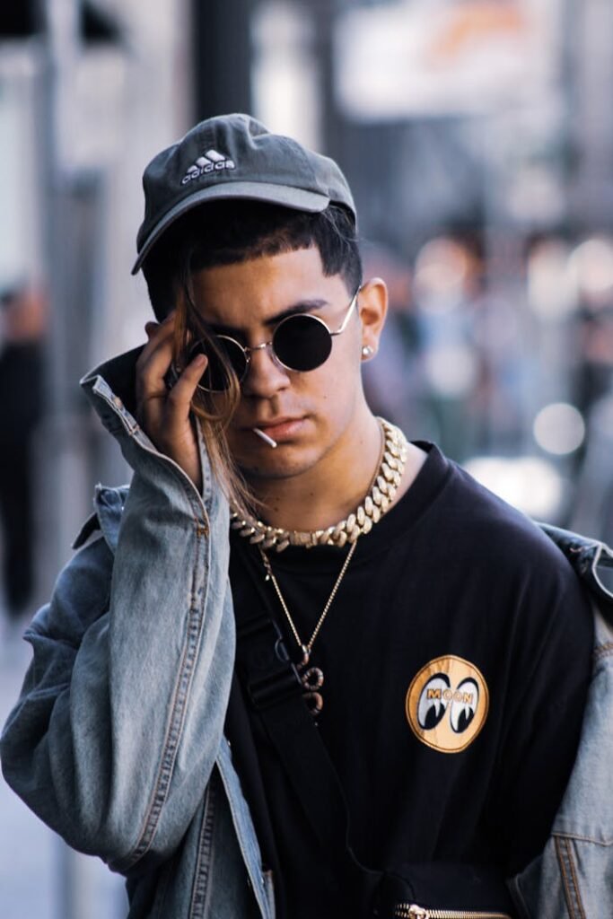 Stylish young man wearing denim and sunglasses, showcasing modern urban fashion.